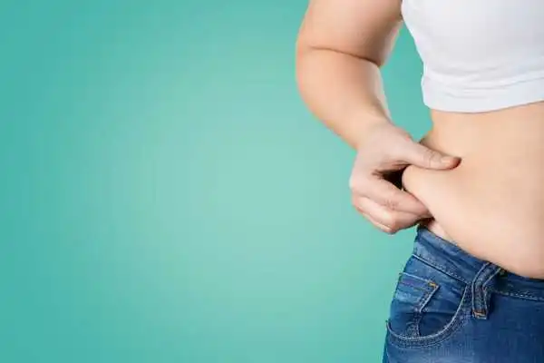 Image of woman pinching her love handles to show weight gain Datchet